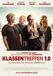 Filmplakat zu "Klassentreffen 1.0". Drei mittelalte lachende Männer mit lockerer dunkler Kleidung, rechts daneben eine junge Frau mit langen blonden Haaren.