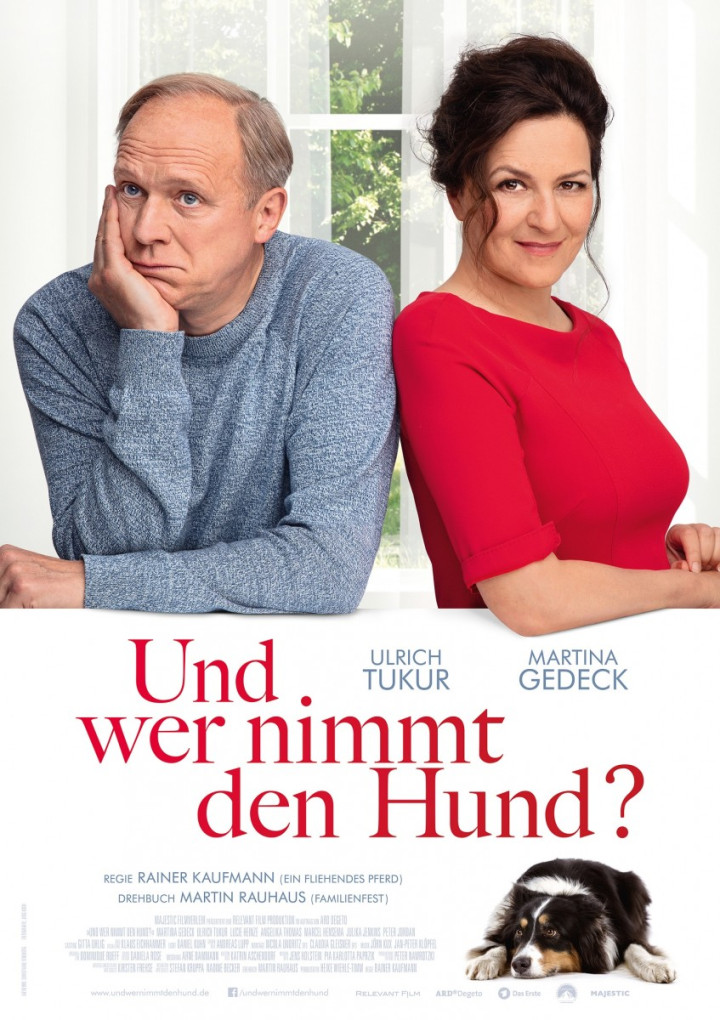 Filmplakat zu "Und wer nimmt den Hund?" Ein Mann mit grauem lichten Haar und blauem Pullover und eine schwarzhaarige Frau in rotem Oberteil.