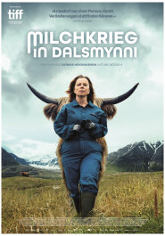 Filmplakat von "Milchkrieg in Dalsmynni". Eine Frau mit langen wehenden Haaren und blauem Overall auf einer Graswiese vor grauem Himmel und hohen Bergen.